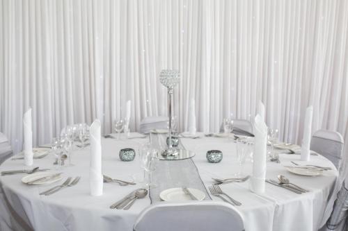 a table with white tablecloths and utensils on it at The Valley Hotel, Anglesey in Valley
