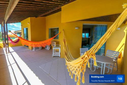 a porch with a hammock and a table and chairs at Casa a beira mar com 4 suites e muito conforto in Porto De Galinhas