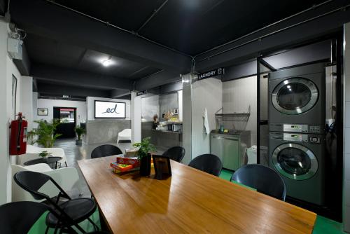 a dining room with a table and chairs and washing machines at Ed Hostel in Chiang Mai