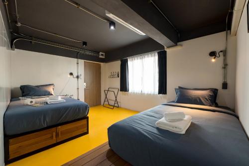a bedroom with two beds and a mirror at Ed Hostel in Chiang Mai