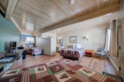 Habitación grande con 2 camas y TV. en Sportsman's Lodge, en Ennis