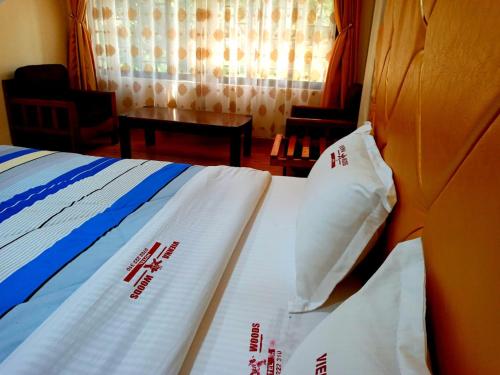 ein Schlafzimmer mit einem Bett mit chinesischer Schrift darauf in der Unterkunft Vienna Woods Hotel Nakuru in Nakuru