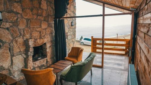 a living room with a stone fireplace and a couch and chairs at Sahil Kamp İstanbul Hotel in Sile