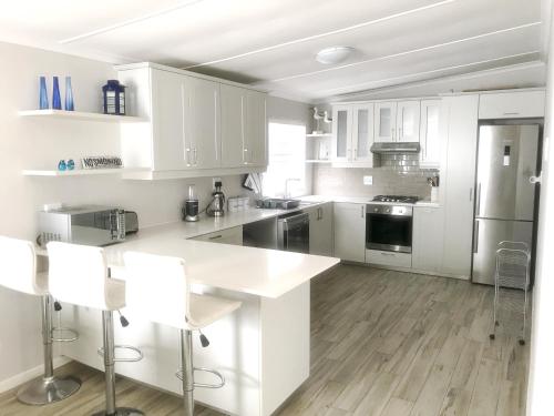 a kitchen with white cabinets and a white counter top at Melkbos Holiday Accommodation in Melkbosstrand