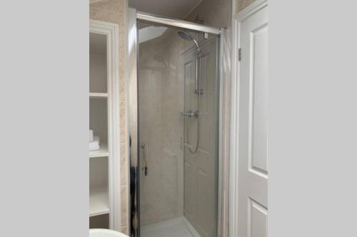 a shower with a glass door in a bathroom at Biskey Howe Central - FREE off-site Health Club access with Pool, Sauna, Steam Room & Gym in Bowness-on-Windermere