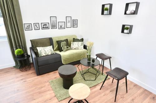 a living room with a couch and a table and chairs at Cosy's Olivier in Larmor-Plage