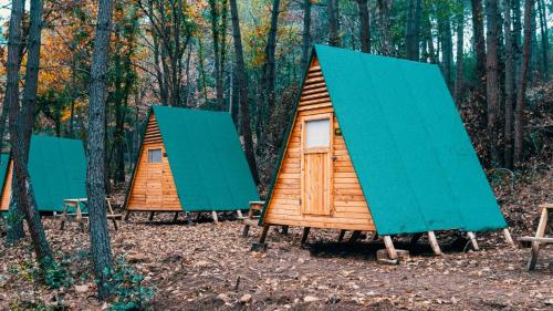 three tents in the woods with blue roofs at Sahil Kamp İstanbul Hotel in Sile