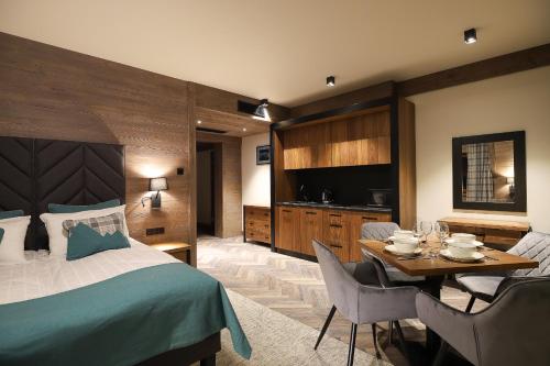 a hotel room with a bed and a dining room at Willa Litworowy Staw in Bukowina Tatrzańska