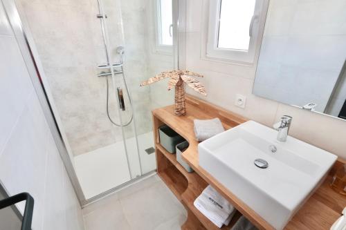 a bathroom with a sink and a shower at Cosy's Olivier in Larmor-Plage