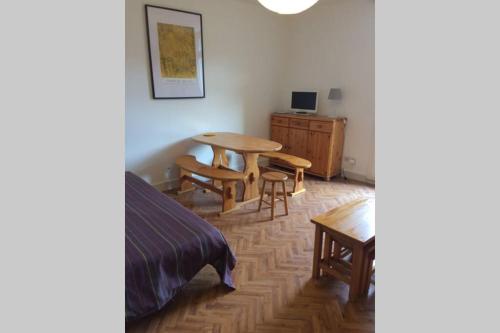 - une chambre avec une table, un lit et un bureau dans l'établissement Studio lumineux avec balcon 2/4 pers. plein centre, à La Bourboule