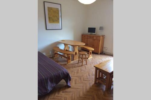 Un dormitorio con una mesa, una cama y un escritorio. en Studio lumineux avec balcon 2/4 pers. plein centre, en La Bourboule