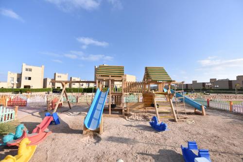 a playground with a bunch of swings in the sand at Tolip North Coast Hotel in El Alamein