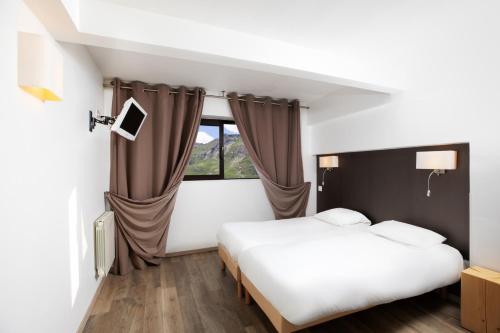 a hotel room with a bed and a window at SOWELL RESIDENCES Crêt Voland in Les Menuires