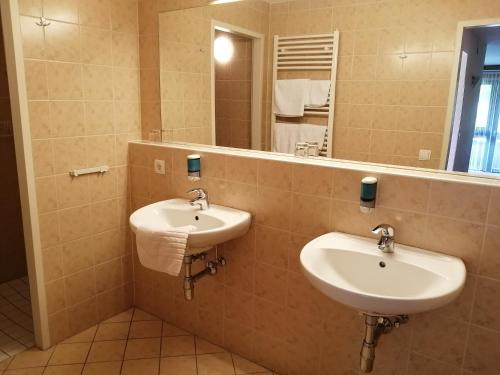 ein Badezimmer mit zwei Waschbecken und einem großen Spiegel in der Unterkunft Haus Anni in Bad Kleinkirchheim