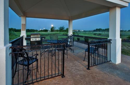 a porch with chairs and tables and a view of a field at Candlewood Suites Olathe by IHG in Olathe