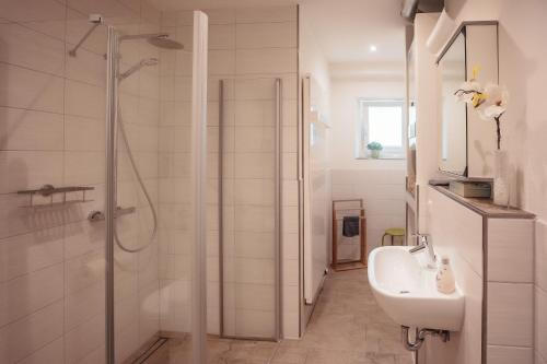 baño blanco con ducha y lavamanos en Ferienwohnung Am Altstadtring en Amberg