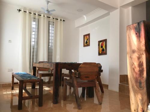 a dining room with a wooden table and chairs at VICK Boutique Hotel with NEW power backup in Nungwi