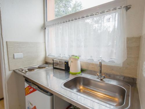 Una pequeña cocina con fregadero y ventana. en Departamentos De la Plaza, en Villa La Angostura