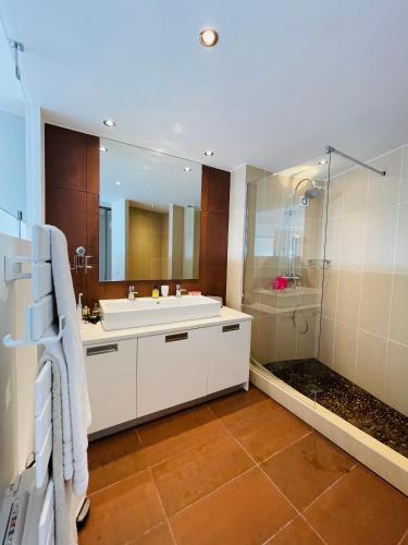une salle de bain avec un lavabo et une douche dans l'établissement Grand appartement - Central Beach - Résidence de la Rose, à Sainte-Maxime