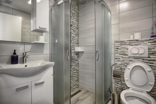 a bathroom with a toilet and a sink and a shower at Rooms DRAGICA in Pakoštane
