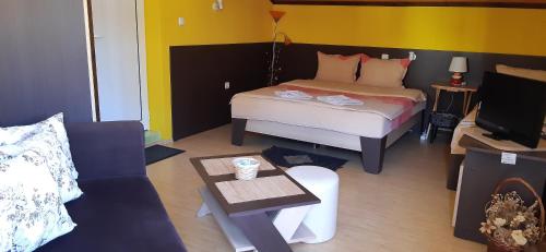 a bedroom with a bed and a tv and a couch at Guesthouse Geto in Belogradchik