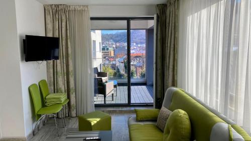 ブラショヴにあるApartament Ultracentral Silvana Dealul Morii Residenceのリビングルーム(緑のソファ、大きな窓付)