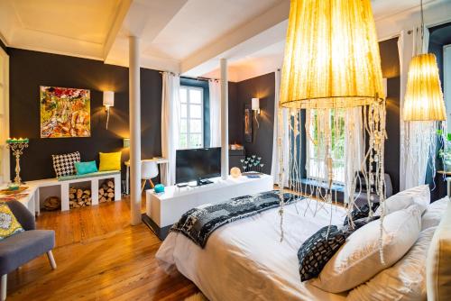 a bedroom with a large bed with a chandelier at charme et standing centre ville in Barcelonnette