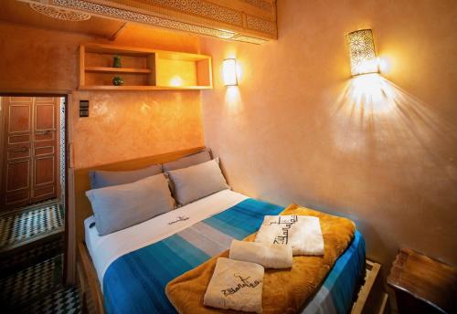 a small bedroom with a bed with two pillows on it at Riad Meski in Fez