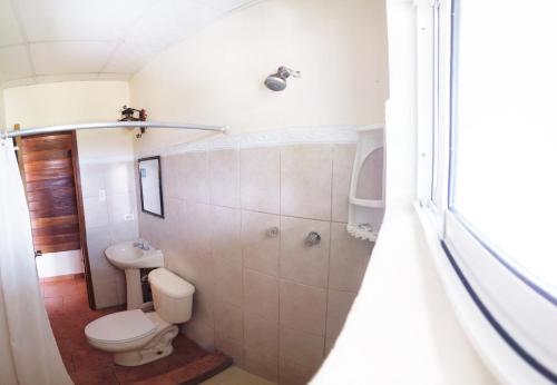 a white bathroom with a toilet and a sink at Hotel Calle 6 in Bocas Town