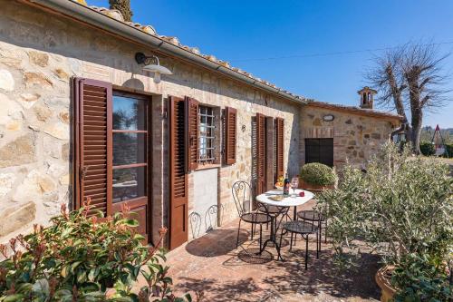 a patio with a table and chairs in front of a building at Il Poderino in Monteriggioni