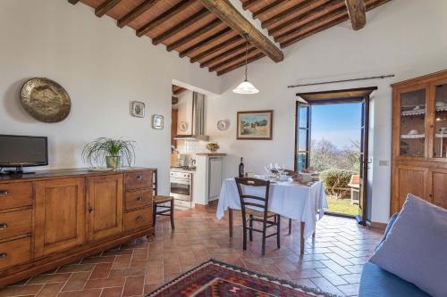 a living room with a table and a kitchen at Il Poderino in Monteriggioni