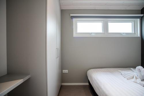 a bedroom with a bed and a window at BUDDHA BEACH BUNGALOWS Adults Only in Zandvoort