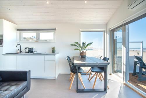 
a kitchen with a dining room table and a large window at BUDDHA BEACH BUNGALOWS Adults Only in Zandvoort
