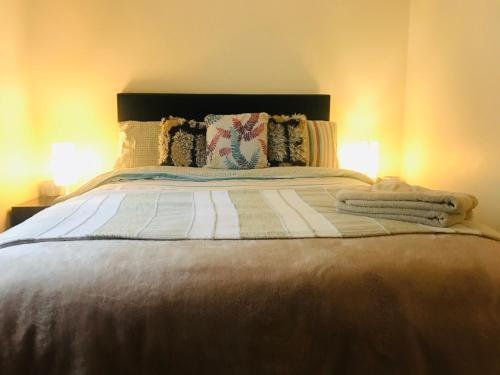 a bedroom with a bed with two lamps on it at Letterkenny Town Centre Apartment in Letterkenny