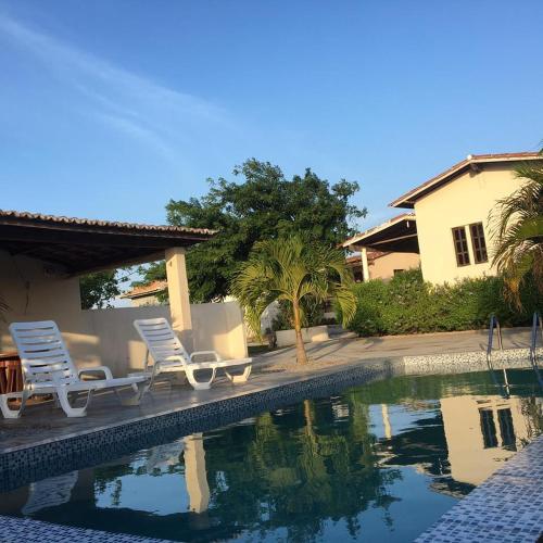 two lawn chairs sitting next to a swimming pool at Pousada Vale Encantado in Serra de São Bento