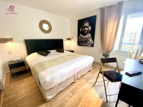 une chambre avec un grand lit blanc dans une pièce dans l'établissement Hotel Les Grenadines, au Cap d'Agde