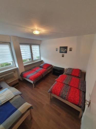a bedroom with two beds and two windows at Ferienwohnung Schloßstraße in Essen