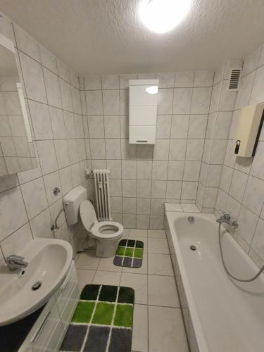 a bathroom with a sink and a toilet and a tub at Ferienwohnung Schloßstraße in Essen