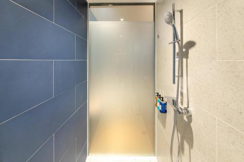 a shower with a glass door in a bathroom at Holiday Inn Express Xiamen Tongan, an IHG Hotel in Xiamen