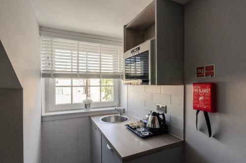 a small kitchen with a sink and a window at Sweeney Motherwell in Motherwell