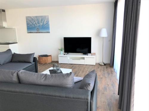 a living room with a couch and a flat screen tv at Meeresrauschen in Laboe