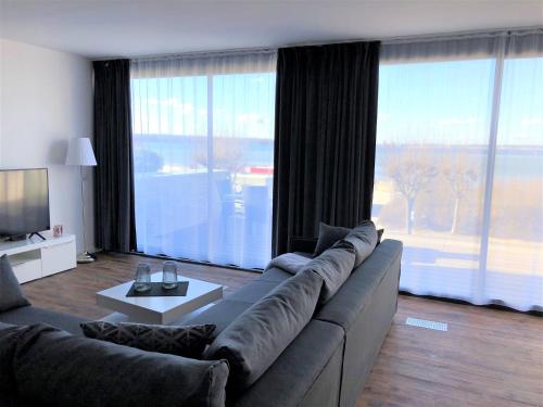 a living room with a couch and a large window at Meeresrauschen in Laboe