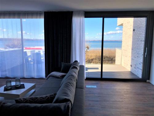 a living room with a couch and a large window at Meeresrauschen in Laboe