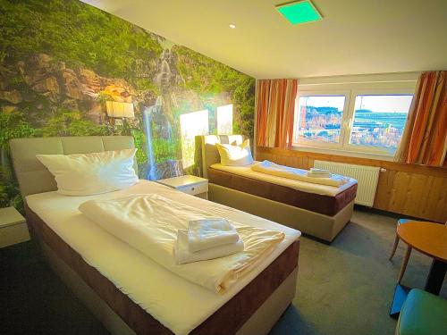 ein Hotelzimmer mit 2 Betten und einem Wandbild in der Unterkunft Meister BÄR HOTEL Frankenwald in Berg