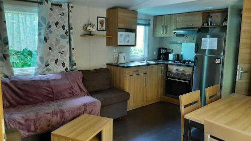 un petit salon avec un canapé et une cuisine dans l'établissement Assist' Mobil Home 262 - Mobil Home Excellence Bora Bora 3 chambres, à Onzain