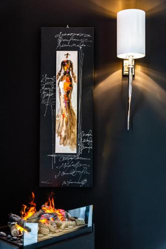 a picture of a woman on a wall next to a lamp at charme et standing centre ville in Barcelonnette