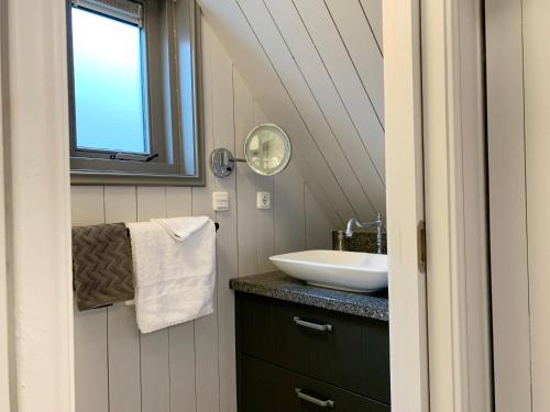 a bathroom with a sink and a mirror at Wetterhûske - Huisje aan de gracht in Franeker