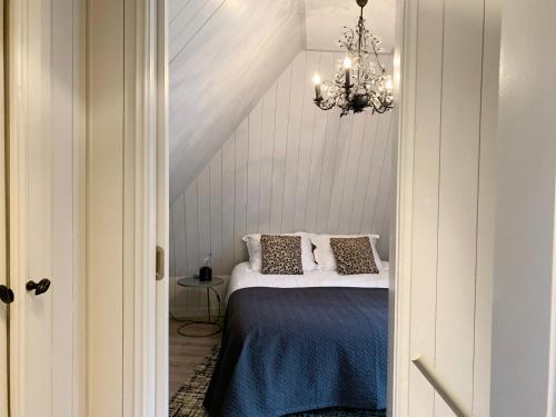 a bedroom with a bed and a chandelier at Wetterhûske - Huisje aan de gracht in Franeker