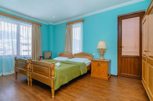 a bedroom with blue walls and a bed and a lamp at Hotel Lileo in Mestia