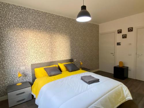 una camera da letto con un grande letto bianco con cuscini gialli di VANNUCCI 71 APT a Perugia
